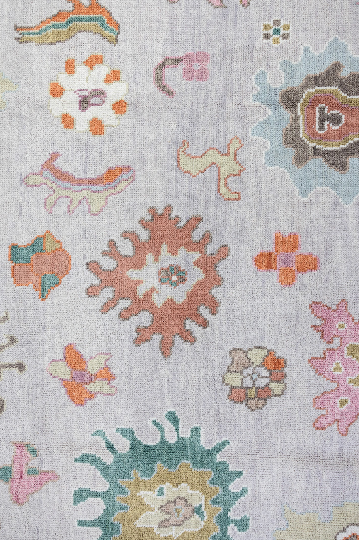Close-up of a patterned rug with floral designs on a light background