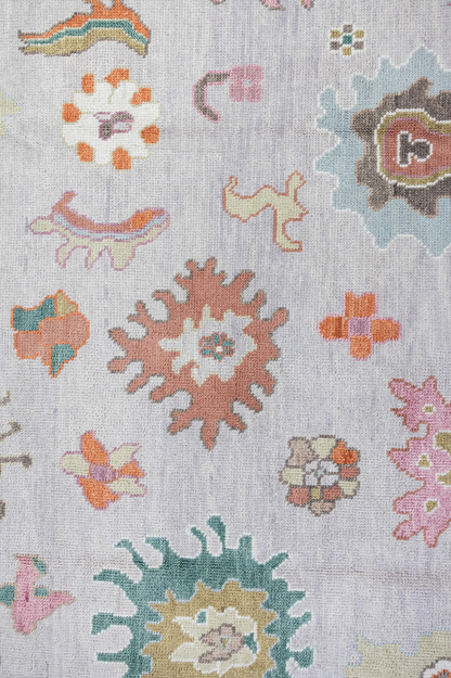 Close-up of a patterned rug with floral designs on a light background