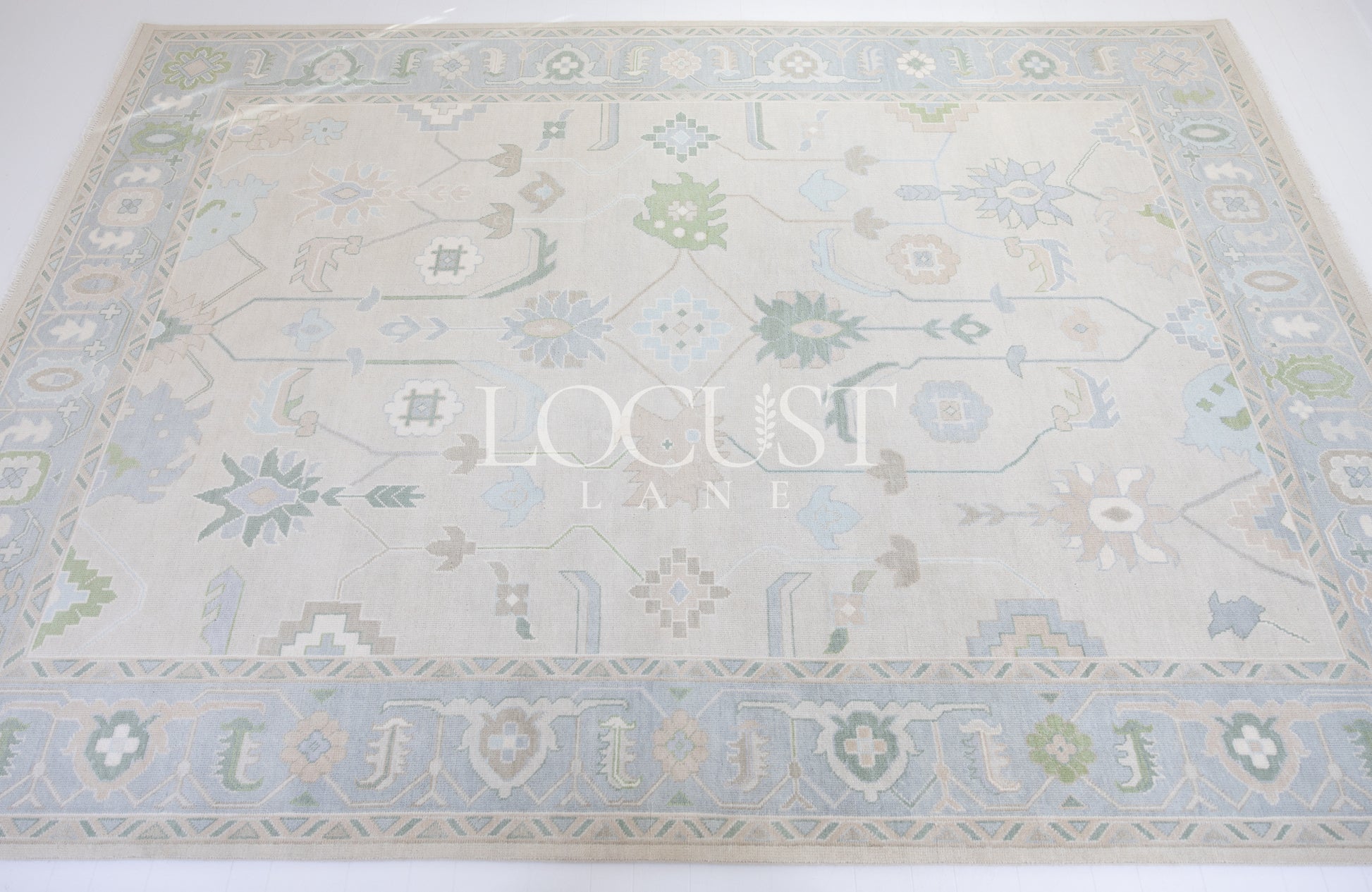Fiona hand-knotted wool Oushak rug in ivory and faded blue from Locust Lane Rugs.