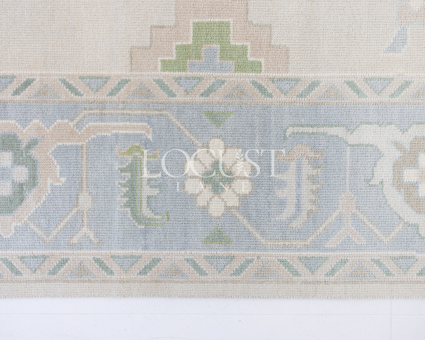 Fiona hand-knotted wool Oushak rug in ivory and faded blue from Locust Lane Rugs.