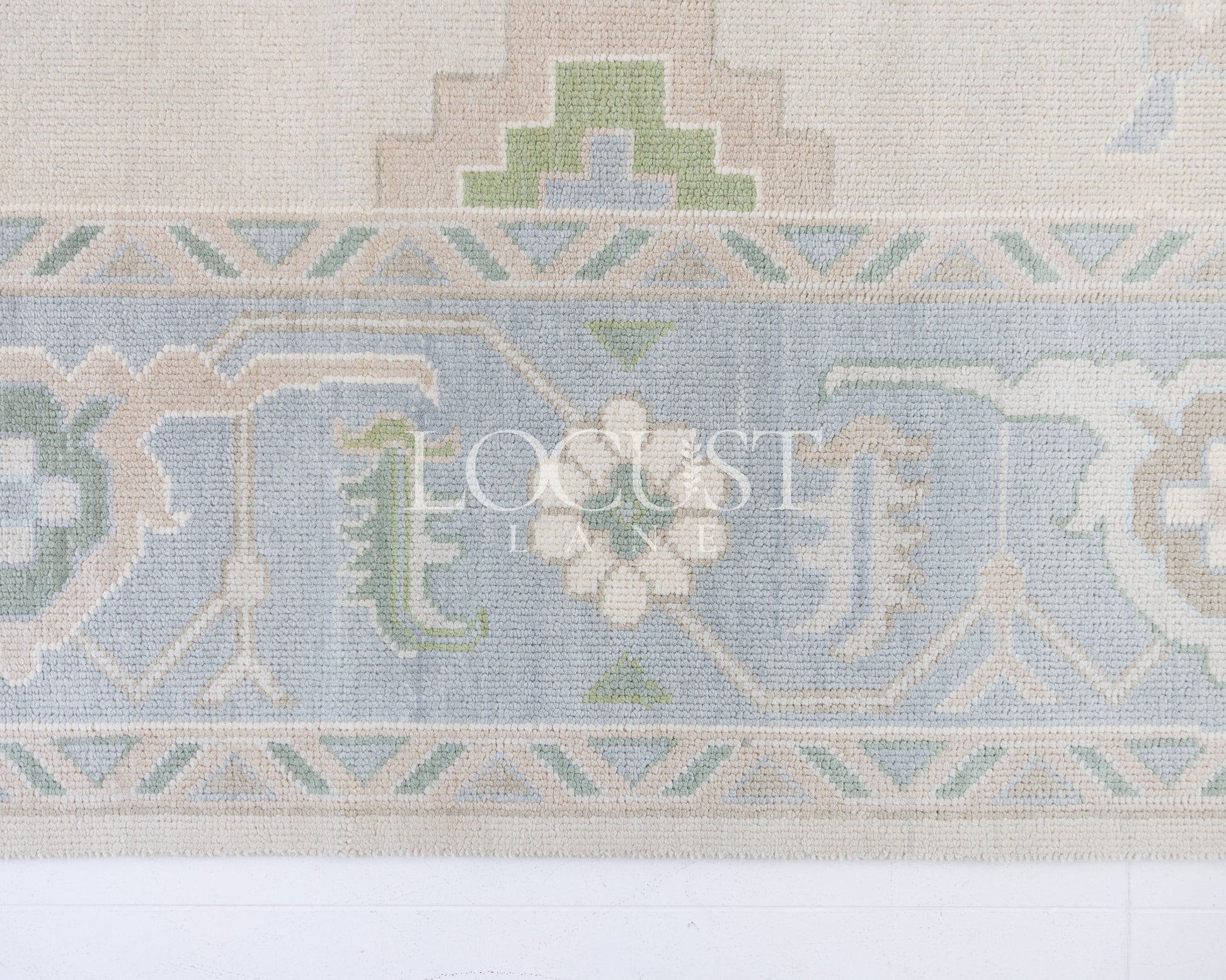 Fiona hand-knotted wool Oushak rug in ivory and faded blue from Locust Lane Rugs.