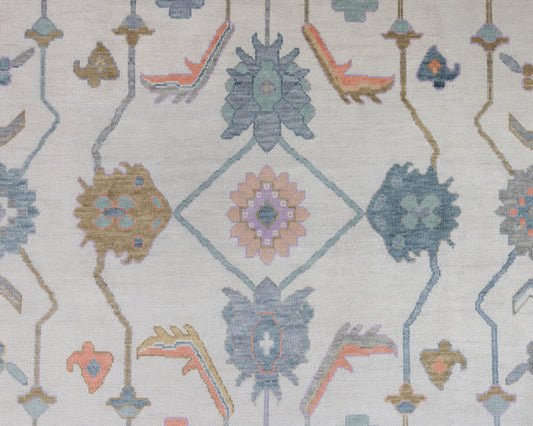 Close-up view of a Jolene Modern Oushak Rug featuring a traditional geometric pattern with melon, teal, marigold, and coral colors on a cool stone ground.