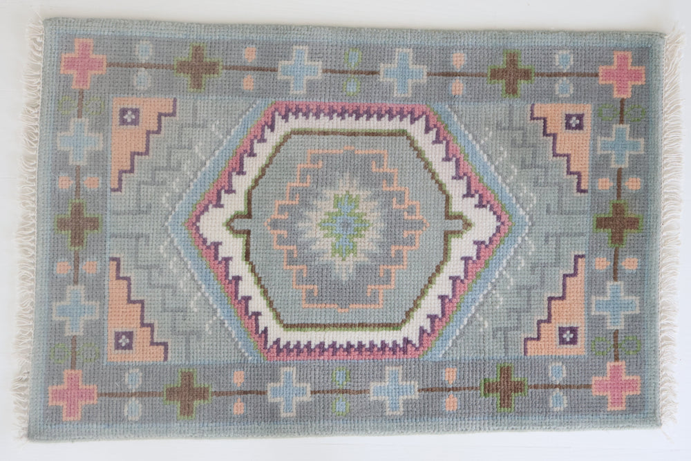 Hand-knotted wool rug featuring a geometric medallion design in soft sky blue, blush, olive, and lavender tones – Maisie Rug by Locust Lane Rugs