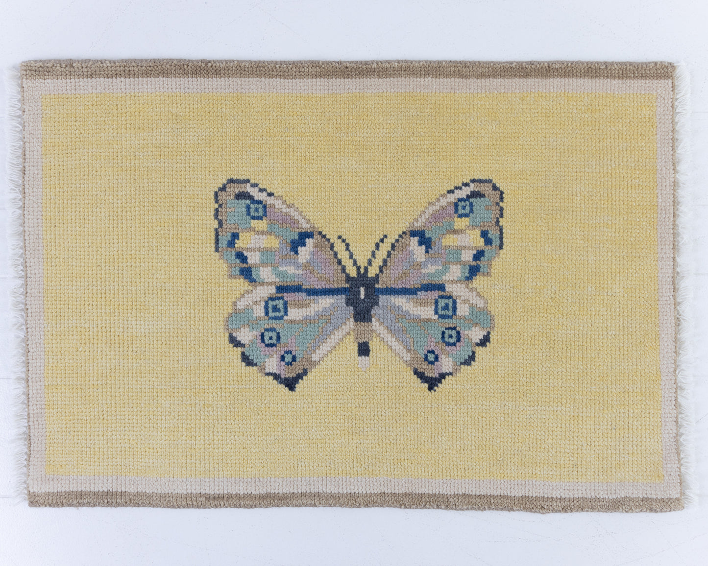 Hand-knotted wool rug featuring a butterfly motif on a buttercream yellow background with ivory border – Yellow Butterfly Mini Rug by Locust Lane Rugs