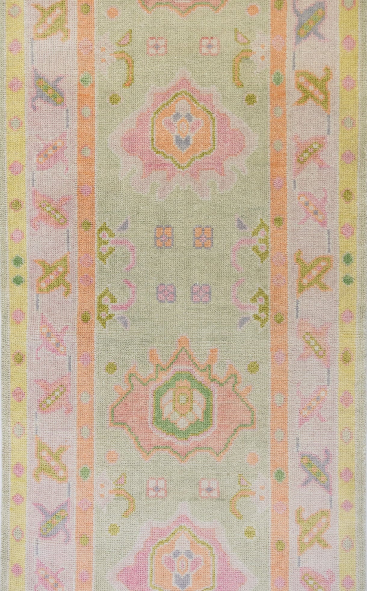 Decorative fabric strip with pastel geometric patterns on a light green background