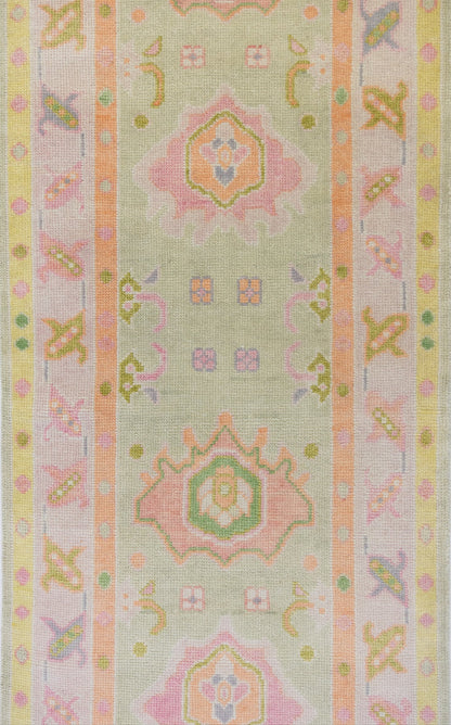 Decorative fabric strip with pastel geometric patterns on a light green background