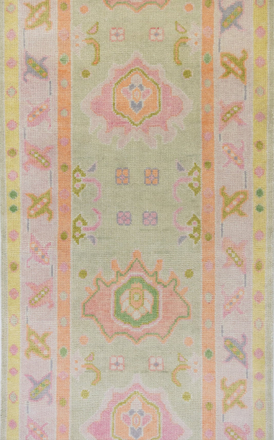 Decorative fabric strip with pastel geometric patterns on a light green background