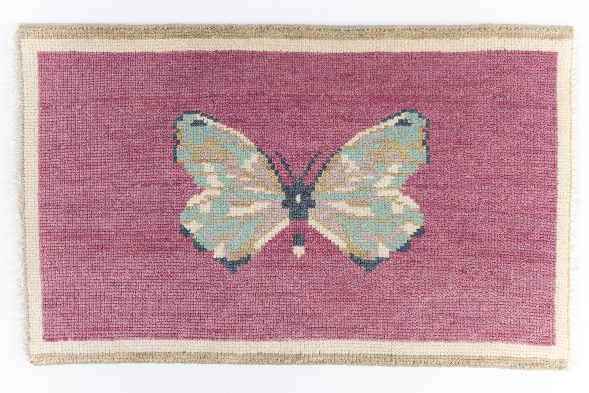 Hand-knotted wool rug featuring a butterfly motif on a magenta background with ivory border – Magenta Butterfly Mini Rug by Locust Lane Rugs