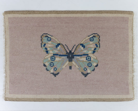 Hand-knotted wool rug featuring a butterfly motif on a soft mauve background with ivory border – Mauve Butterfly Mini Rug by Locust Lane Rugs