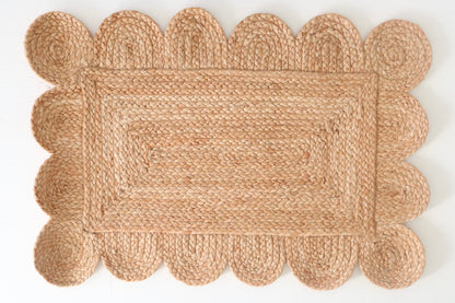 Natural scalloped jute mini rug with hand-braided rectangular weave and protective backing by Locust Lane Rugs