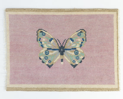 Hand-knotted wool rug featuring a butterfly motif on a blush pink background with ivory border – Pink Butterfly Mini Rug by Locust Lane Rugs