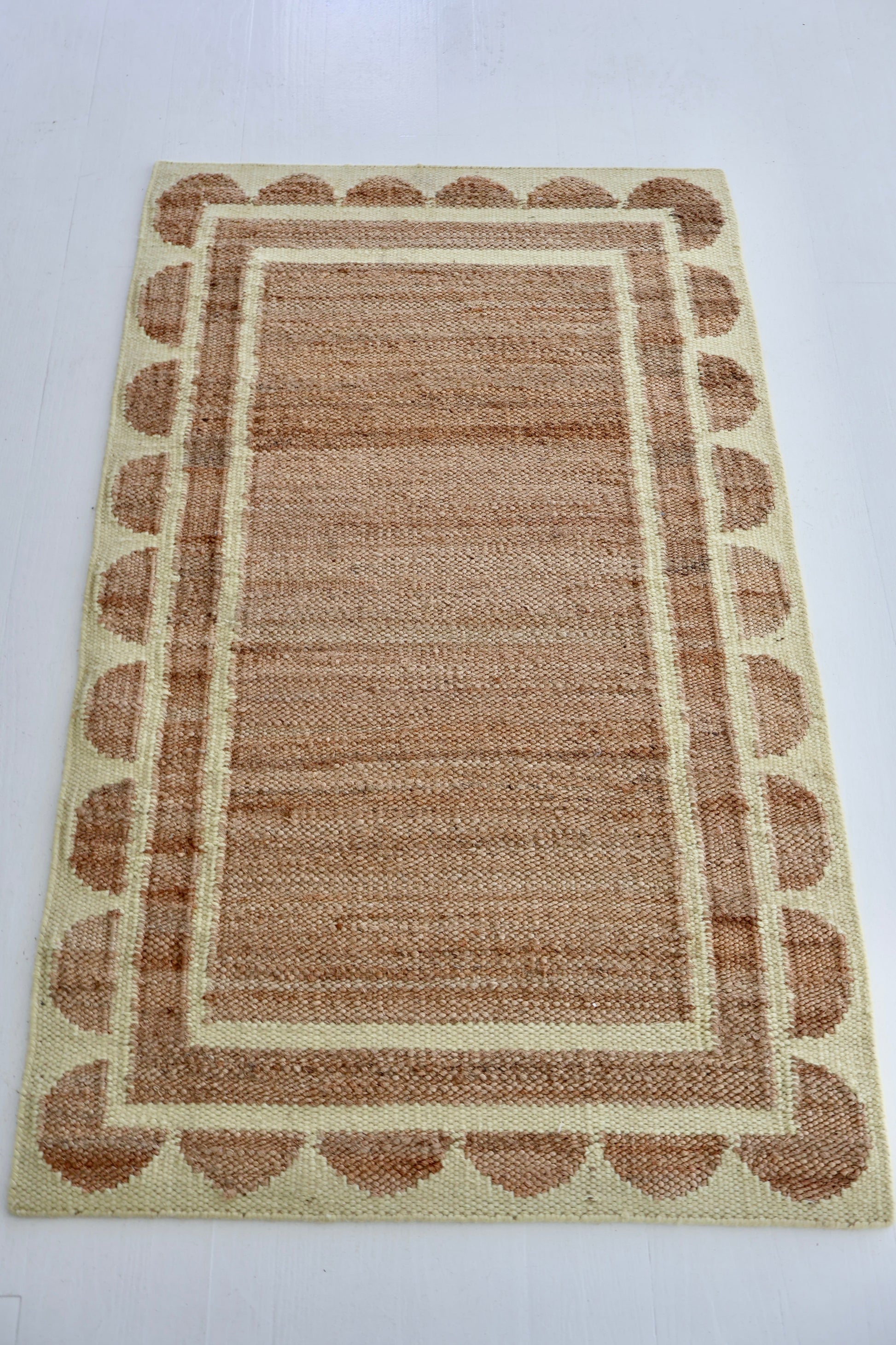 Handwoven jute and wool rug in natural tones with a pear-green scalloped border – Sweet Pear Scalloped Edge Rug by Locust Lane Rugs